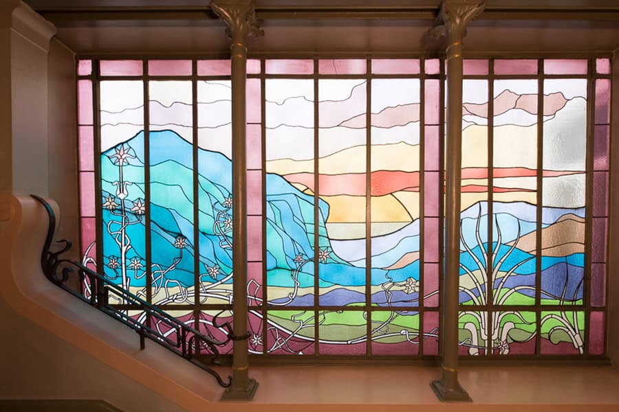 Vitrail coloré représentant un paysage de montagnes et de nature, art stained glass festival.